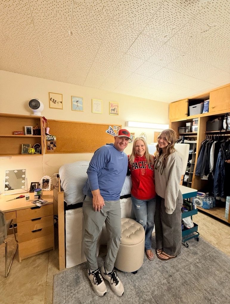 Mike, Michelle and Reese standing together in Reese's dorm room on move-in day